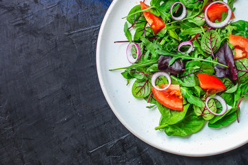 healthy salad (tomato, mix leaves, onions and other ingredients) vegan top menu concept. food background. copy space