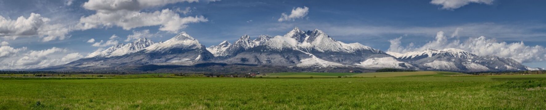 Extra wide panorama of High Tatra mounatins with main ridge during April with snowy hills and blue sky with clouds, Vysoke Tatry, Slovakia