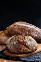 Freshly baked homemade artisan bread on wooden board. Healthy food.