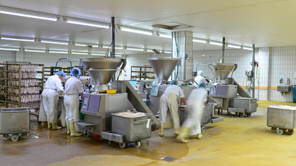 Arbeiter in einer Fleischerei - Herstellung von Würsten in einer Fabrik für Lebensmittel //...