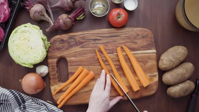 Step by step. Flat lay. Slicing orange carrots into the small cubes for beet soup, borscht.