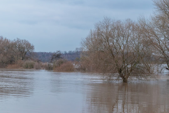 &Uuml;berschwemmung und &uuml;berflutete Auenlandschaft nach Hochwasser durch starke Regenf&auml;lle, Tsunami oder Schneeschmelze mit Deichbruch als extreme Wetterkapriolen mit &Uuml;berflutungsgefahr