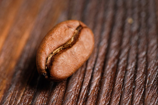 The perfect coffee bean on a burnt wooden background.