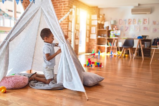 Beautiful African American Toddler Playing Inside Tipi Smiling At Kindergarten