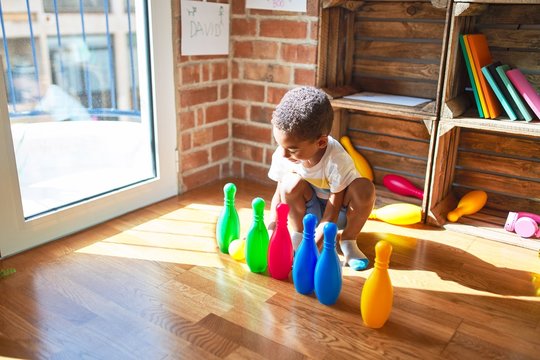 Beautiful african american toddler playing bowling at kindergarten