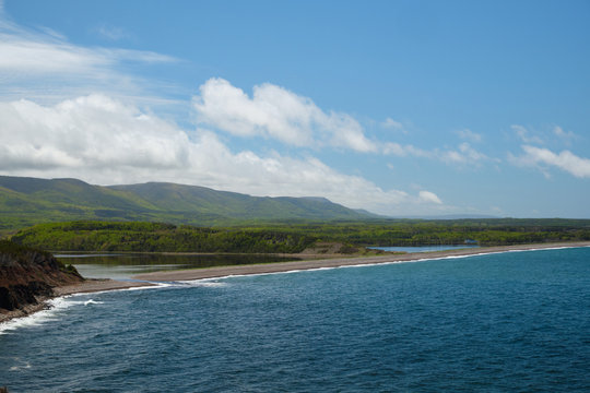 View On A Lagoon, Coastline Of Nova Scotia And Green Forest. Blue Cloudy Sky And Mountains.