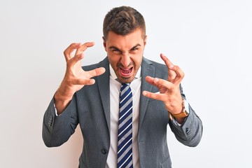 Young handsome business man wearing suit and tie over isolated background Shouting frustrated with rage, hands trying to strangle, yelling mad