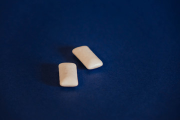 two white chewing gums on a blue background