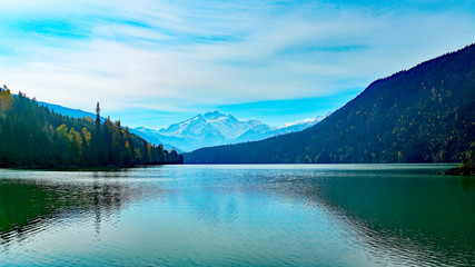 Lake with green water, mountains and sky