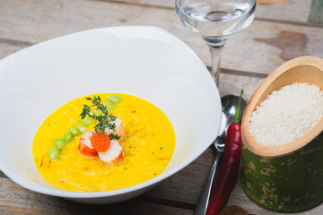 Traditional rice with seafood, risotto with rice and shrimp in a deep white plate on a table in a restaurant.