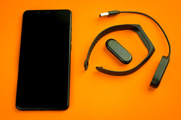 Black fitness watch (activity tracker) on a smartphone, health-saving technologies, modern...
