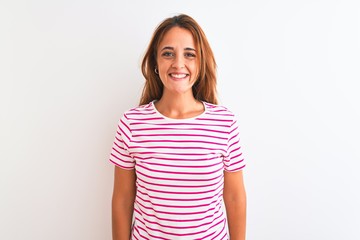 Fototapeta premium Young redhead woman wearing striped casual t-shirt stading over white isolated background with a happy and cool smile on face. Lucky person.