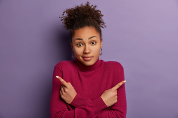 No idea. Puzzled reluctant dark skinned woman points sideways, indicates left and right, cannot...
