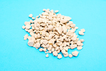 Zeolite mineral stone, zeolite pebbles isolated of blue background.