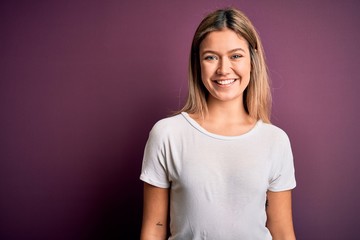 Fototapeta premium Young beautiful blonde woman wearing casual white t-shirt over purple isolated background with a happy and cool smile on face. Lucky person.