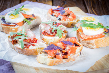 Bruschetta with tomato and basil, bruscetta with salmon and eggs, bruscetta with prosceutto and rucola