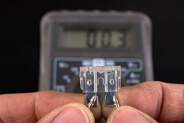 Measurement of resistance of car fuses with an electric meter. Checking the conductivity of...