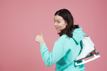 Figure skating, Hobbies and a healthy active lifestyle. A cheerful girl in a bright hoodie with skates on her shoulder