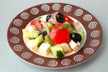 Part of a plate with patterns, filled with fresh delicious Greek salad. Health food. Vegetarianism
