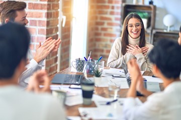 Group of business workers smiling happy and confident. Working together with smile on face applauding one of them at the office