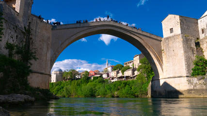 Fototapeta na wymiar Mostar, Bosnia and Herzegovina, April 2019: Old town and Neretva River. The town was destroyed during the Croat-Bosniak war in 1993, reconstructed and now a UNESCO World Heritage