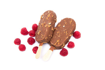 Chocolate ice cream with nuts, on a stick and a raspberry lying nearby. Concepts of healthy, tasty, nutrition.