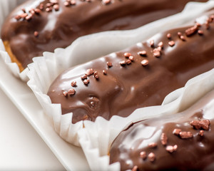chocolate eclairs with icing and powder.Сlose-up