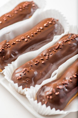 chocolate eclairs with icing and powder.Сlose-up