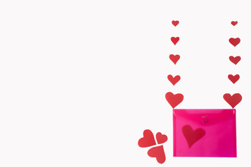 pink envelope with red hearts on a white background. valentine's day concept. Hearts like balloons carry an envelope.