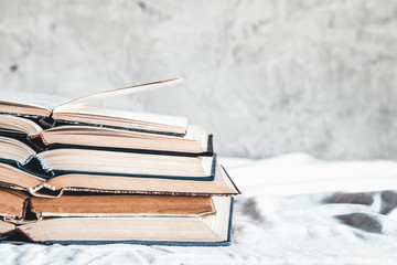 Opened books in a stack on a light home background. Education, hobbies