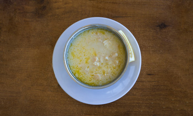 Tripe soup in a bowl / plate with lemon on wooden table background. Traditional soup of Gaziantep, Turkey. Famous symbol Turkish cuisine fresh food foams. Veal meat ingredients in regional soup. Khash