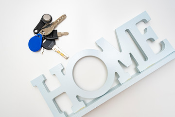 A bunch, set of metal keys and a home sign on white background