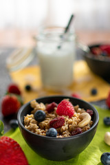 leckeres Müsli mit frischen Früchten. Im unscharfen Hintergrund Kokosmilch mit Strohhalm