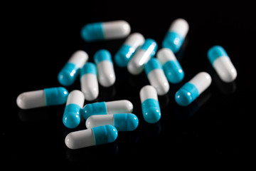 Pharmacy background on a dark table. Levitation pills. Tablets on a dark background which falling down. Pills. Medicine and healthy. Close up of capsules. Pills falling on black background