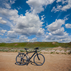 Fototapeta premium closeup bicycle on a sandy sea beach under a cloudy sky