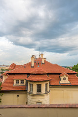 View of the top of old buildings with red roof and dramatic sky at Prague city Czech republic.