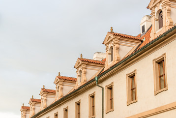 View of the top of old buildings with red roof and dramatic sky at Prague city Czech republic.