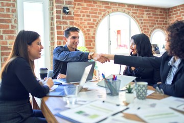 Group of business workers smiling happy and confident. Working together with smile on face shaking hands for agreement at the office