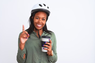 Young african american woman wearing bike helmet and drinking coffee over isolated background surprised with an idea or question pointing finger with happy face, number one