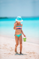 Adorable little girl playing with beach toys on white tropial beach