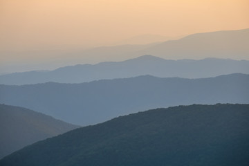 mountain ridge silhouette in a blue mist at the twilight
