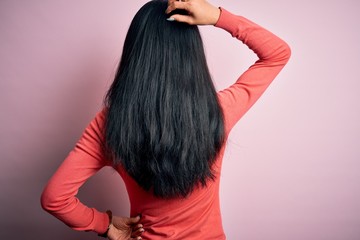 Fototapeta premium Young beautiful chinese woman wearing casual sweater over isolated pink background Backwards thinking about doubt with hand on head