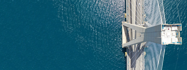 Aerial drone ultra wide photo of suspension cable bridge over deep blue sea