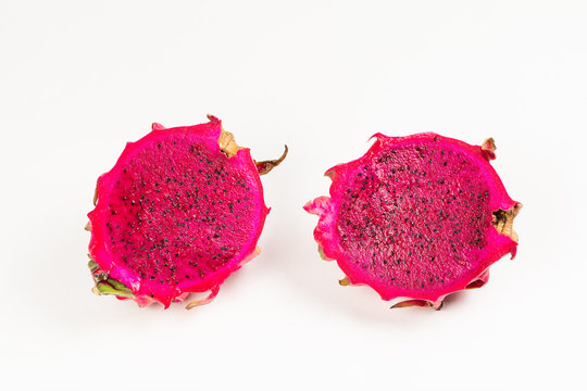 Half cut pieces of red gragon fruit on white background