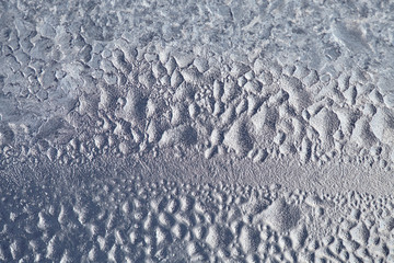 Texture of Frozen drops of condensed steam water drops on the transparent window glass. Clean background. Water vapor condenses on cold window glass and freezes into ice