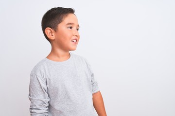Beautiful kid boy wearing grey casual t-shirt standing over isolated white background looking away...