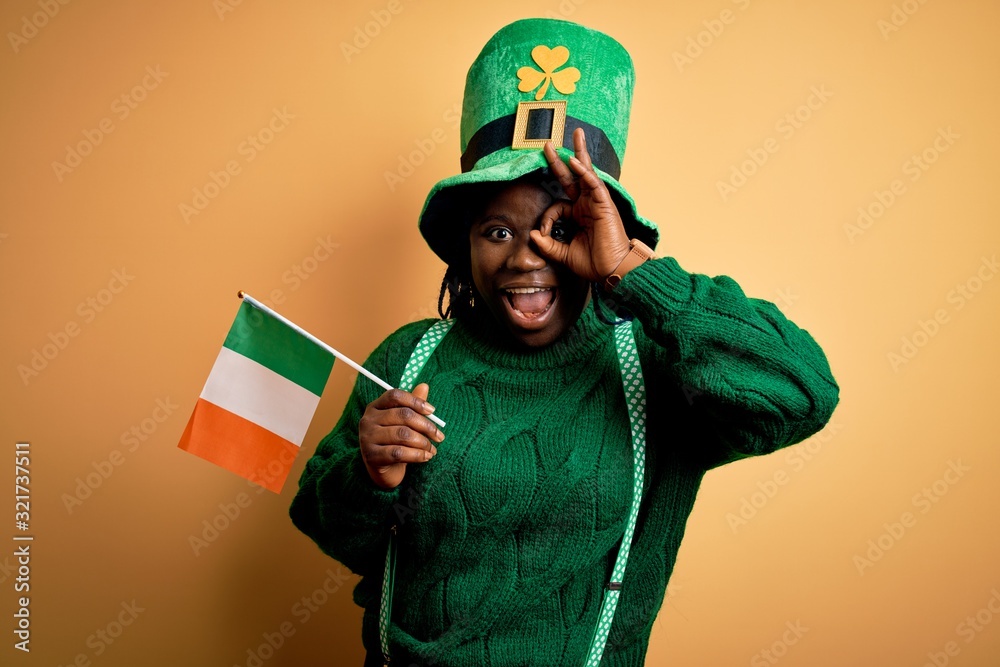 Sticker plus size african american woman wearing green hat holding irish flag on saint patricks day with hap