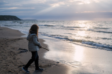 Long-haired girl in warm clothes by the North sea