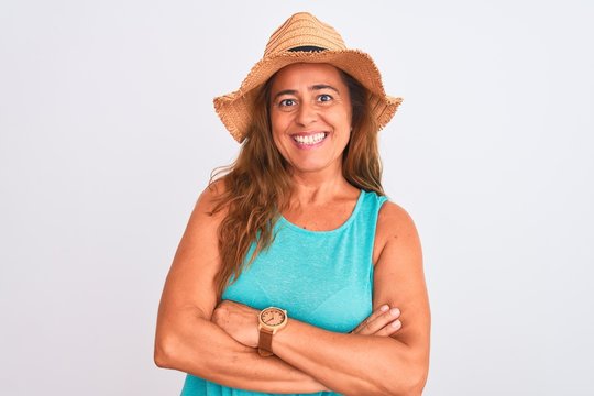 Middle age mature woman wearing summer hat over white isolated background happy face smiling with crossed arms looking at the camera. Positive person.