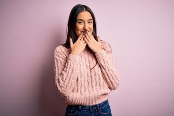 Young beautiful brunette woman wearing casual sweater over isolated pink background laughing and...